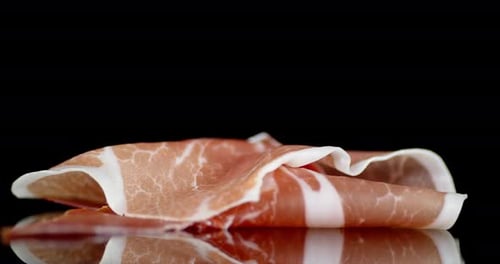 Delicious Slice of Prosciutto on Black Background