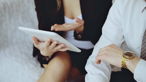 Business Man And Woman Discussing Business With Tablet Computer.