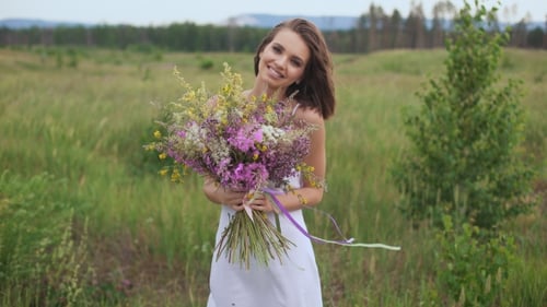 Beautiful Inspired Woman Holds a Bouquet Of Wildflowers.