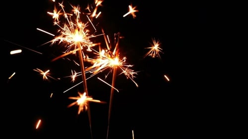 Sparkling Flames Erupting from Handheld Sparklers in Dark