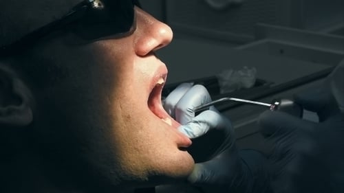 Dentist Drilling Patient's Teeth in a Dental Office