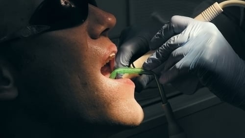 Man Receives Dental Treatment from Dentist Close Up