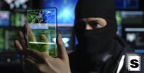 Masked Hacker Using Digital Interface to Access Data