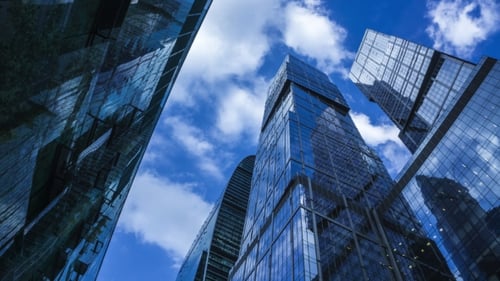 Modern Reflective Skyscrapers Against Cloudy Sky