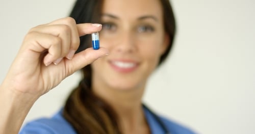 Woman Doctor Holding Pill in Close-up View