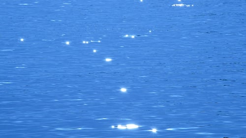 Funken in blauen Wellen Wasser des Meeres