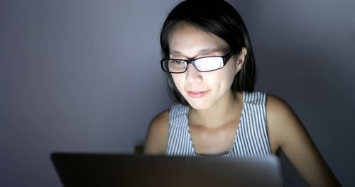 Woman Working on Laptop Computer at Night