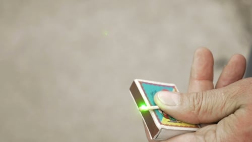 Guy Is Lighting Matchstick With a Green Laser Beam