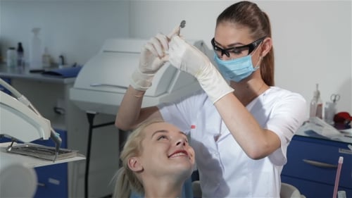 Zahnärztin verwendet zahnärztliches Werkzeug zur Überprüfung der Zähne des Patienten
