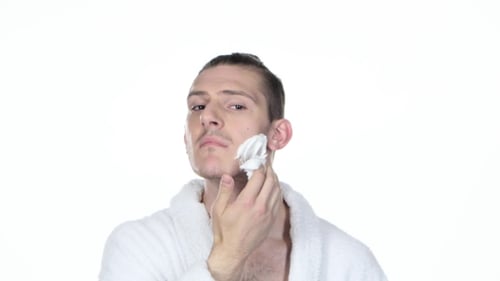 Man in Bathrobe Applying Shaving Cream to Face
