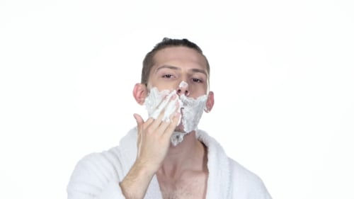 Man Applying Shaving Cream to Face in Bathroom