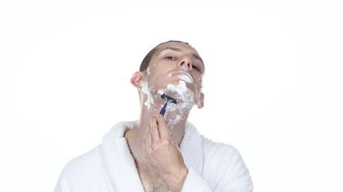 Man Shaves with Razor and Shaving Cream