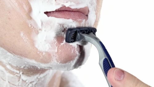 Man Shaves with Razor and Cream