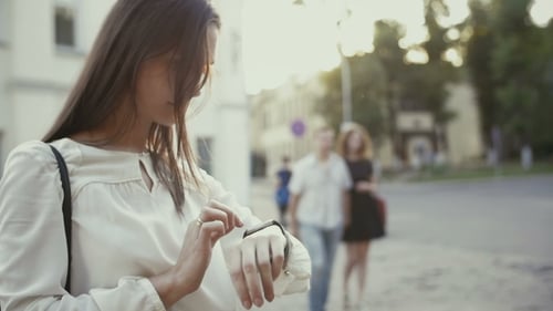 Woman Uses Smartwatch Standing In Old City