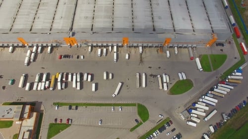 Aerial view of the logistics warehouse with trucks waiting for loading