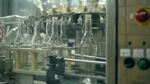 Many Bottles Of Vodka Or Gin On Conveyor Belt In Factory. Bottling Plant