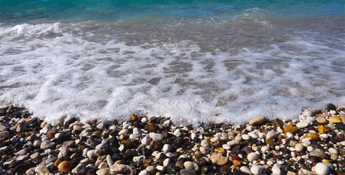 Waves Washing onto Rocky Beach on Sunny Day