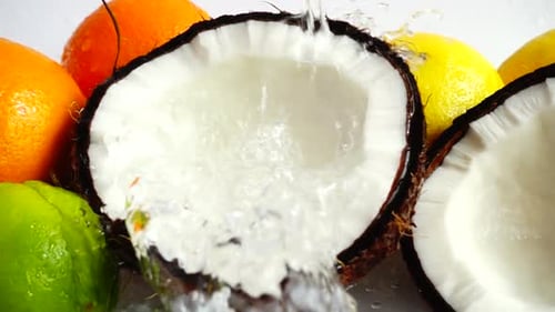 Refreshing Water Splashing Into Half-Cut Coconut Close Up