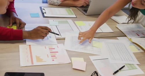 Diversos compañeros de trabajo masculinos y femeninos con documentos en la reunión
