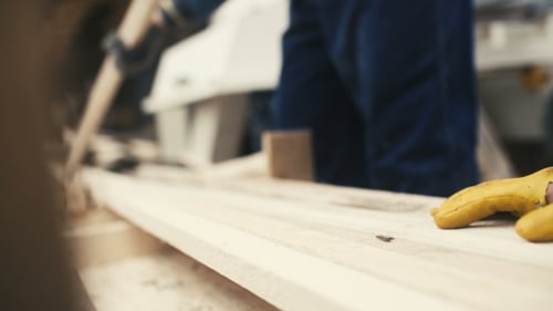 Woodworker Prepares Wood on Workbench Indoors