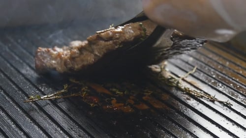 A Cook Turns Up a Steak Of Meat On a Grill In