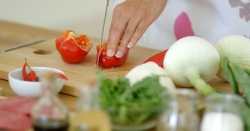 Woman Dicing Fresh Red Pepper on Cutting Board