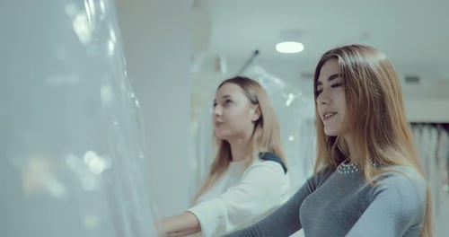 Noiva feliz e bonita escolhe um vestido de noiva