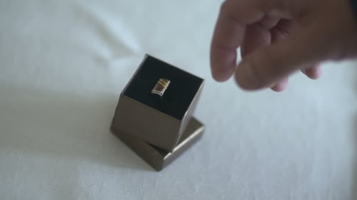 Man Opens Ring Box Showing Wedding Bands