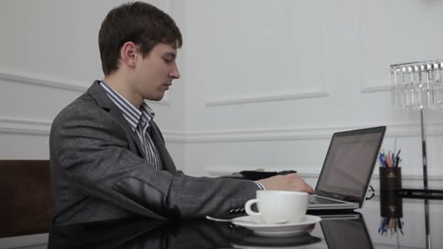 Mann trinkt Kaffee während der Arbeit.