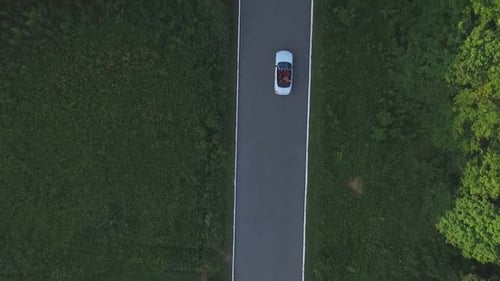 Aerial Shot of White Convertible Car Riding Through Empty Rural Road. Four Young Unrecognizable