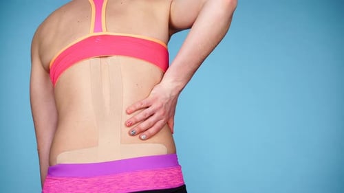 Terapia de cinta kinesio para dolor de espalda de mujer