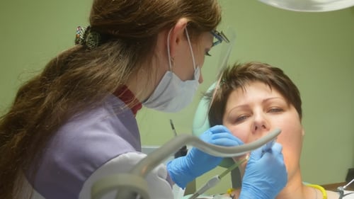 Dentist Performing Dental Procedure on Woman