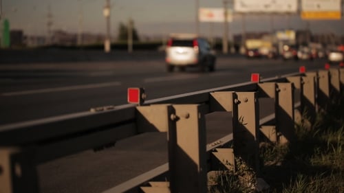 Movement Of Cars On Highway In Sunny Day. Roadside In Area Of Focus.