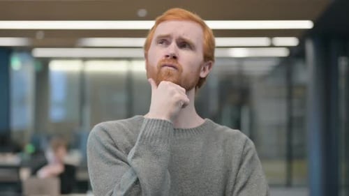 Man With Red Hair Ponders in Office