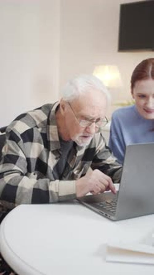 El viejo aprende a usar la computadora mientras su nieta lo ayuda