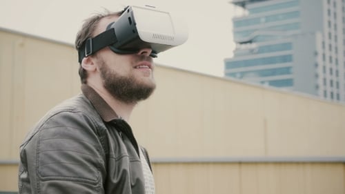 Bearded Attractive Man Uses Virtual Reality Glasses on the Roof