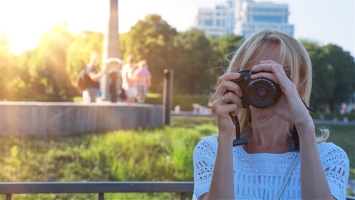Woman Photographer Taking Pictures in Sunny City Park