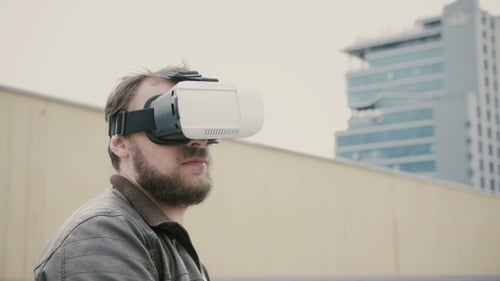 Bearded Attractive Man Uses Virtual Reality Glasses On The Roof.