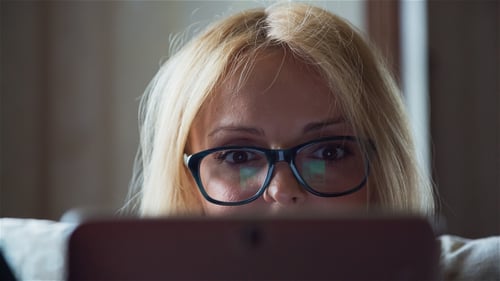 Woman in Glasses Uses Tablet Device Indoors
