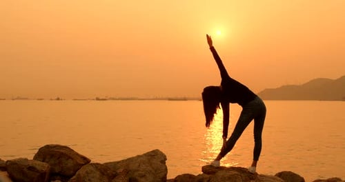 Woman Doing Yoga on Beach at Sunset