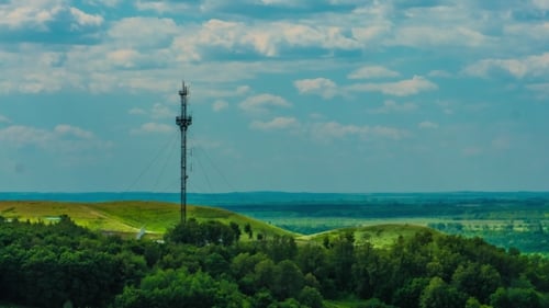 Telecommunications Tower Communications On a Background Of Sky Clouds