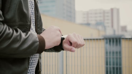 Man Using Smartwatch in Urban Setting