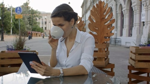 Handsome Young Woman Is Using a Digital Tablet In a Cafe.