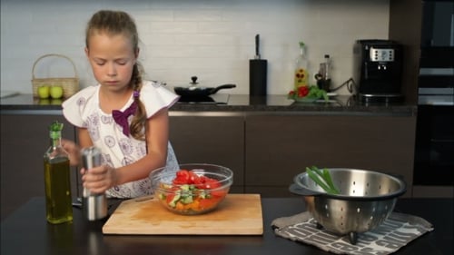 Girl Prepares Salad in Modern Kitchen