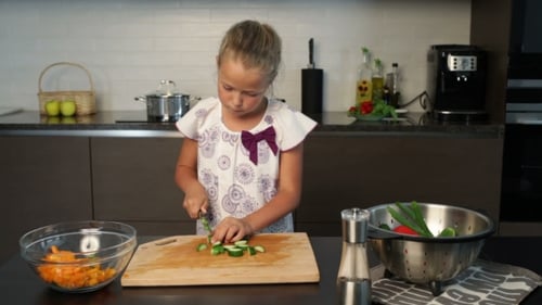 Girl Chopping Cucumber in Bright Kitchen