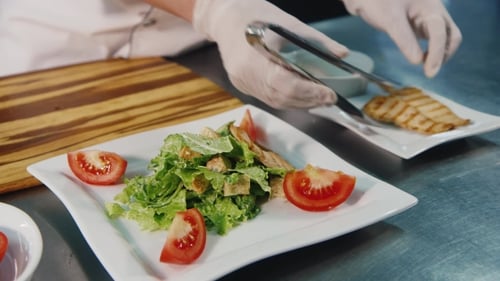 Chef préparant la salade César, dans le cadre, seules les mains visibles