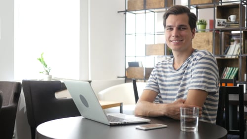 Young Adult Sitting at Table Smiling