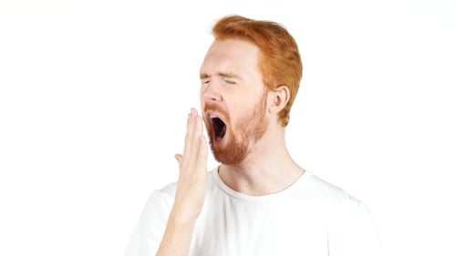 Man Yawns in Front of a White Background