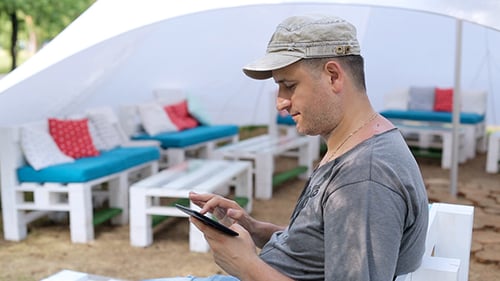 Mann benutzt Tablet im Park