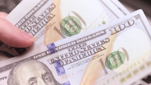 Hand Fanning Hundred Dollar Bills Over Keyboard